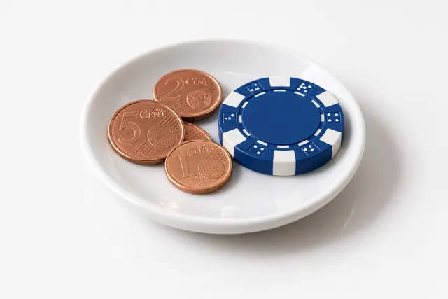 Saucer with a few cents and one casino chip