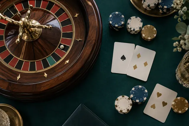 Roulette wheel, blackjack cards and chips seen from above